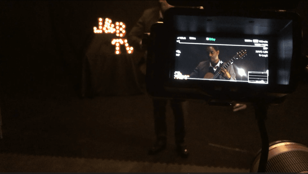 camera monitor showing man playing guitar